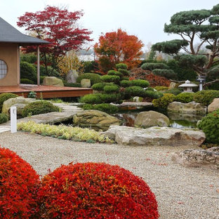Réalisation d'un très grand jardin à la française arrière asiatique l'automne avec une entrée ou une allée de jardin, une exposition ensoleillée et du gravier.