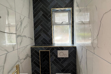 This is an example of a contemporary family bathroom in Buckinghamshire with a one-piece toilet, multi-coloured tiles, porcelain tiles and a wall-mounted sink.