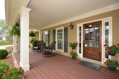 This is an example of a mid-sized traditional front yard verandah in Atlanta with decking and a roof extension.