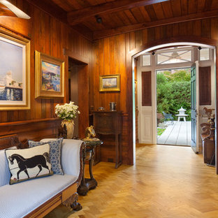 Bild på en stor eklektisk farstu, med bruna väggar och ljust trägolv