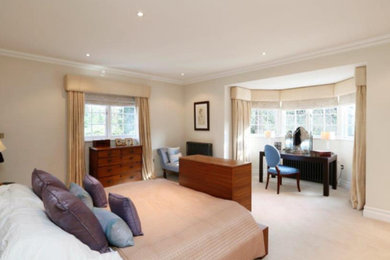 Design ideas for a medium sized contemporary master bedroom in London with beige walls, carpet, no fireplace and beige floors.