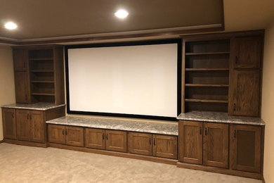 Example of a large classic enclosed carpeted and beige floor home theater design in Other with beige walls and a projector screen