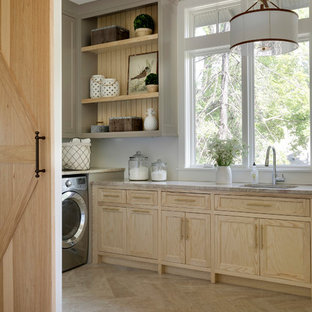 Inspiration for a rural l-shaped separated utility room in Minneapolis with a submerged sink, recessed-panel cabinets, light wood cabinets, white walls, a side by side washer and dryer, beige floors and beige worktops.