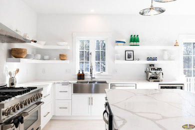Inspiration for a large country l-shaped light wood floor and white floor kitchen pantry remodel in Boston with white cabinets, marble countertops, an island and white countertops