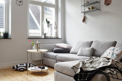 Kleines, Abgetrenntes Nordisches Wohnzimmer ohne Kamin mit weißer Wandfarbe und hellem Holzboden in Köln