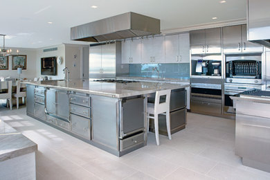 Kitchen - large industrial kitchen idea in New York with an undermount sink, flat-panel cabinets, stainless steel cabinets, glass sheet backsplash, stainless steel appliances and an island