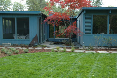 Inspiration for a mid-sized mid-century modern partial sun backyard stone landscaping in Chicago.