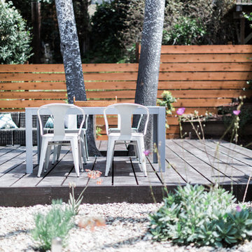 IKEA FALSTER Table with White Tolix Marais Chairs on Outdoor Deck with Woven Tra