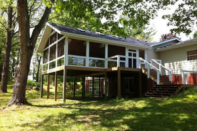 Mid-sized trendy screened-in back porch photo in Other with decking and a roof extension