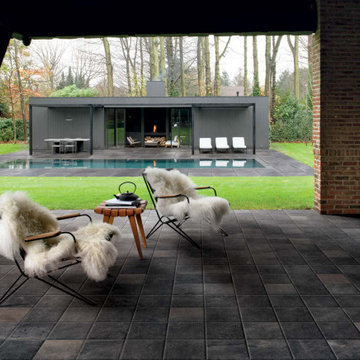 Contemporary backyard pool with dark grey stone look porcelain tiled floors