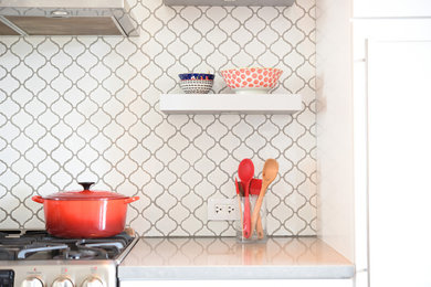 Danish single-wall cork floor eat-in kitchen photo in New York with an undermount sink, shaker cabinets, white cabinets, quartzite countertops, white backsplash, porcelain backsplash, stainless steel appliances and an island