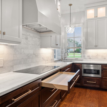 Corner view of an L-shaped two-tone kitchen with an extended prep drawer