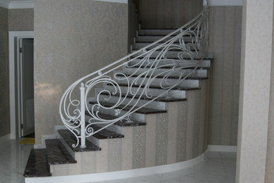 Источник вдохновения для домашнего уюта: изогнутая бетонная лестница в стиле модернизм с мраморными ступенями и металлическими перилами