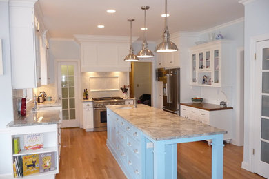 Large transitional u-shaped light wood floor eat-in kitchen photo in Milwaukee with a farmhouse sink, recessed-panel cabinets, white cabinets, granite countertops, white backsplash, subway tile backsplash, stainless steel appliances and an island