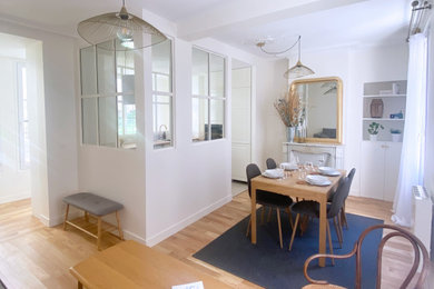 Cette photo montre une salle de séjour chic de taille moyenne et ouverte avec parquet clair, une cheminée standard, un manteau de cheminée en pierre et un sol beige.