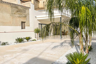 Modelo de patio mediterráneo grande en patio trasero con huerto y losas de hormigón