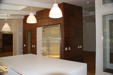 Enclosed kitchen - large contemporary l-shaped light wood floor and brown floor enclosed kitchen idea in San Diego with a single-bowl sink, flat-panel cabinets, white cabinets, solid surface countertops, blue backsplash, mosaic tile backsplash, stainless steel appliances and an island