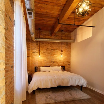 Bedroom with exposed brick walls and ceiling beams