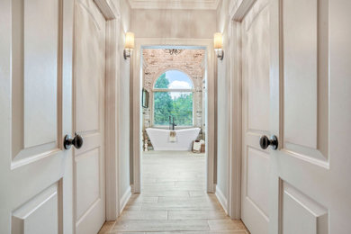 Bathroom - large traditional master gray tile and ceramic tile ceramic tile, beige floor, single-sink, vaulted ceiling and brick wall bathroom idea in Atlanta with white cabinets, a freestanding vanity, furniture-like cabinets, a one-piece toilet, beige walls, an undermount sink, granite countertops, a hinged shower door and white countertops