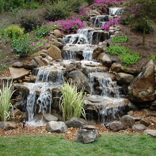 Design ideas for a mid-sized traditional backyard partial sun formal garden for fall in Nashville with natural stone pavers and with waterfall.
