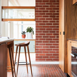 Inspiration for a midcentury kitchen in Melbourne with marble benchtops, brick floors, red floor and yellow benchtop.