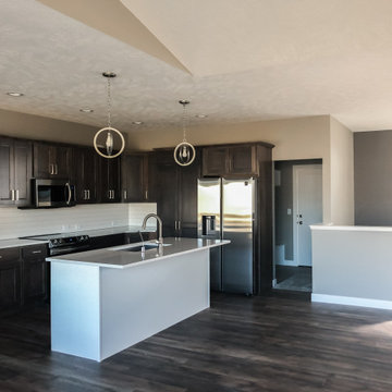 Kitchen with microwave over glass stop stove and subway tile backsplash