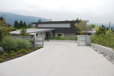 Design ideas for a large traditional front yard full sun driveway in Vancouver with concrete pavers.