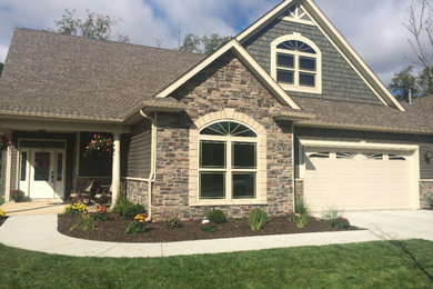 Mid-sized traditional beige two-story mixed siding gable roof idea in Other