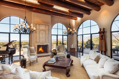 This is an example of an expansive mediterranean formal open concept living room in Albuquerque with beige walls, dark hardwood floors, a standard fireplace, a stone fireplace surround and no tv.