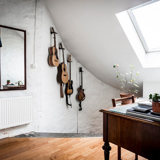 Foto på ett litet skandinaviskt arbetsrum, med vita väggar