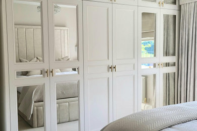 Design ideas for a medium sized traditional built-in wardrobe in Other with shaker cabinets, carpet and feature lighting.