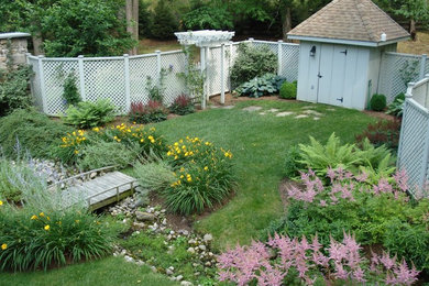 This is an example of a traditional backyard garden in Baltimore with a water feature.