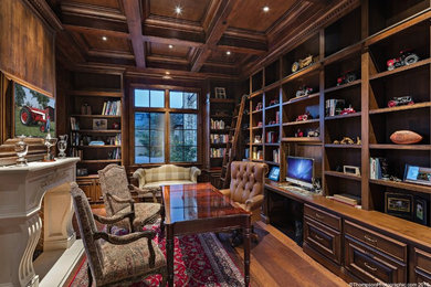 Home office - traditional freestanding desk medium tone wood floor home office idea in Phoenix with a standard fireplace and a stone fireplace