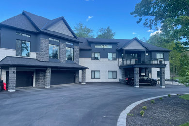 Inspiration for a huge modern two-story stone house exterior remodel in Ottawa