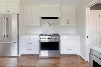 Example of a galley brown floor eat-in kitchen design in Other with a drop-in sink, white cabinets, quartz countertops, white backsplash, subway tile backsplash, stainless steel appliances, no island and white countertops