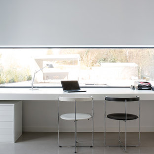 Design ideas for a large modern study in Hamburg with white walls, concrete flooring, a built-in desk and no fireplace.