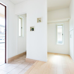 Esempio di un corridoio minimalista con pareti bianche, pavimento in compensato, una porta singola, una porta in legno scuro e pavimento beige