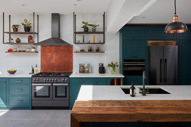 Design ideas for a medium sized contemporary galley kitchen/diner in London with a double-bowl sink, shaker cabinets, turquoise cabinets, composite countertops, white splashback, black appliances, an island, grey floors and white worktops.