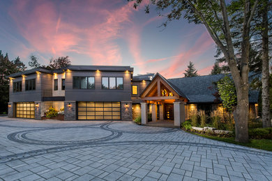 Large arts and crafts multicolored two-story mixed siding house exterior photo in Edmonton with a clipped gable roof and a metal roof