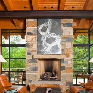 На фото: огромная гостиная-столовая в стиле модернизм с паркетным полом среднего тона, стандартным камином, фасадом камина из камня, бежевыми стенами и бежевым полом с