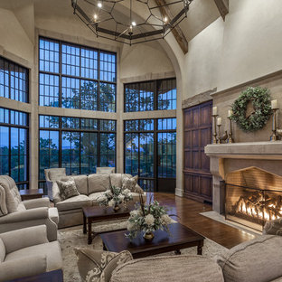 Photo of a large mediterranean living room in Other with beige walls, medium hardwood flooring, a wood burning stove, a stone fireplace surround, a concealed tv and brown floors.