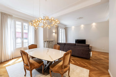 Idées déco pour une grande salle à manger ouverte sur le salon classique avec un mur beige, un sol en bois brun et éclairage.