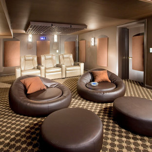 Idée de décoration pour une salle de cinéma minimaliste de taille moyenne et fermée avec un mur marron, moquette, un téléviseur fixé au mur et un sol multicolore.
