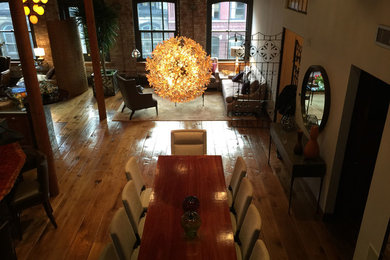 Eclectic dining room in New York with white walls and medium hardwood floors.