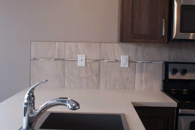 Eat-in kitchen - traditional u-shaped laminate floor eat-in kitchen idea in Calgary with a double-bowl sink, shaker cabinets, medium tone wood cabinets, laminate countertops, white backsplash, ceramic backsplash, stainless steel appliances and a peninsula