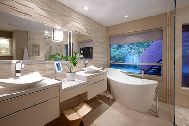 Contemporary bathroom in San Francisco with a vessel sink, flat-panel cabinets, a freestanding tub, a curbless shower and beige tile.