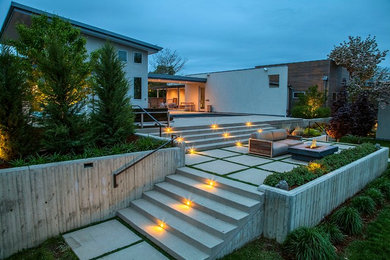 Large modern backyard patio in Denver with a fire feature, concrete pavers and no cover.