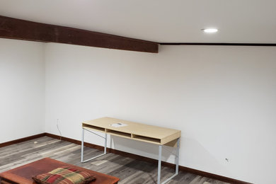 Inspiration for a mid-sized craftsman underground vinyl floor, gray floor, coffered ceiling and brick wall basement remodel in Other with a home theater and white walls