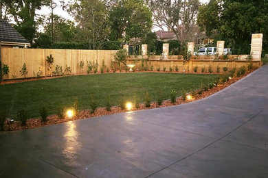 Photo of a mid-sized modern front yard driveway in Sydney with mulch.