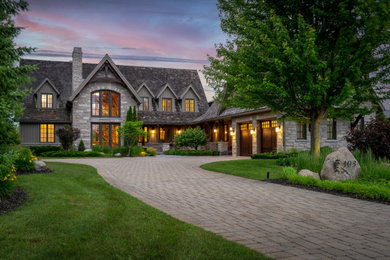 Transitional gray two-story stone exterior home photo in Toronto with a shingle roof and a gray roof